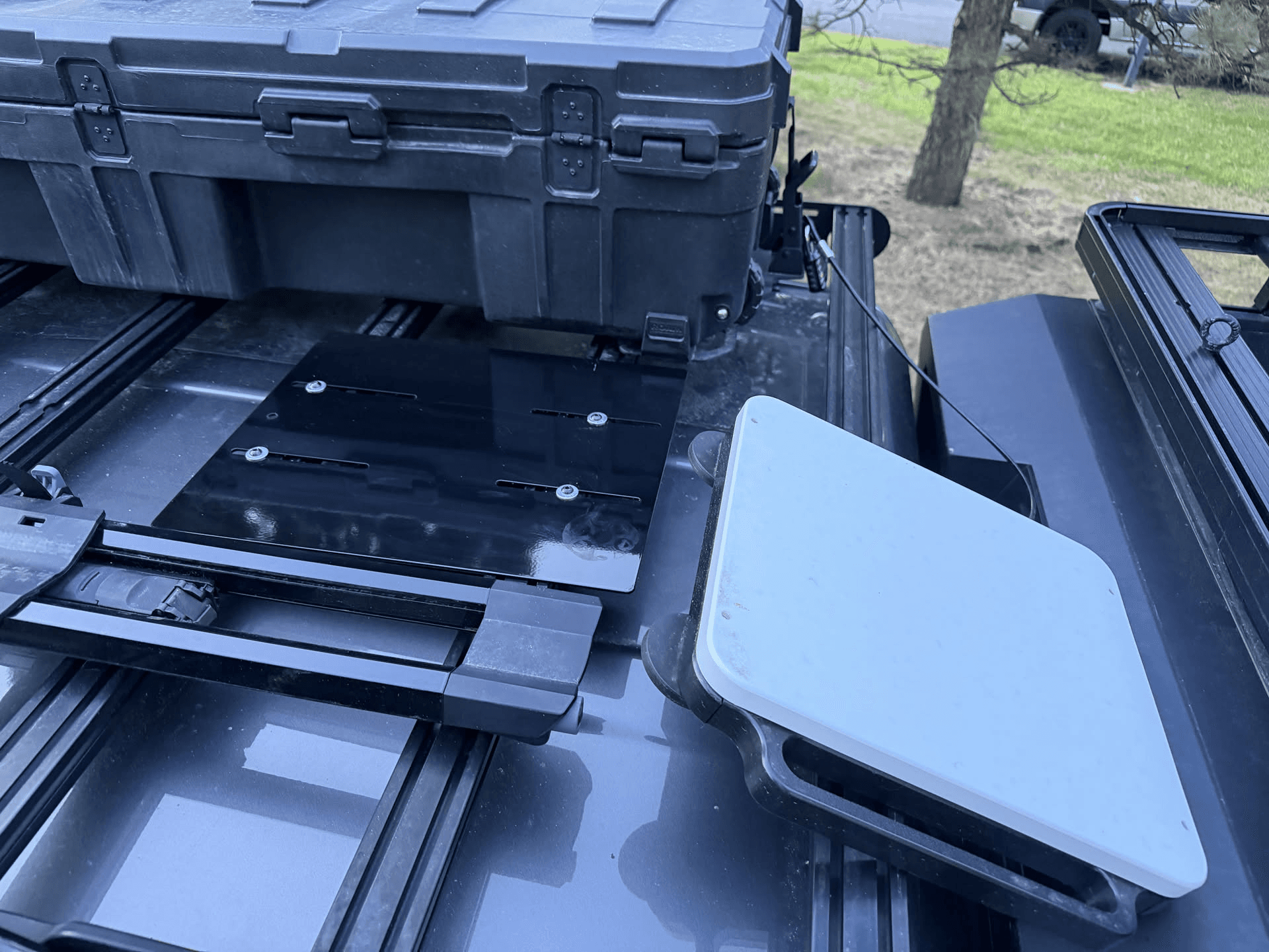 Close-up of the powder-coated Starlink Magnet Plate showing slots and mounting hardware under a storage box